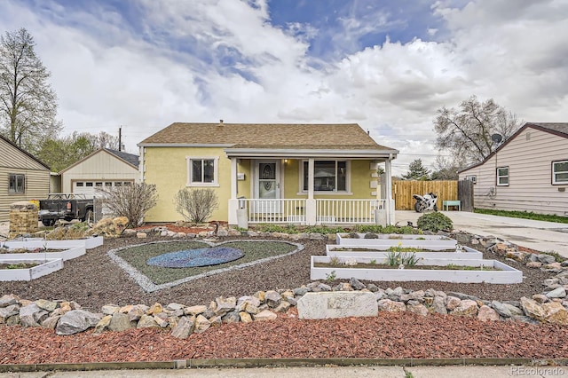 bungalow featuring an outdoor structure, a garden, fence, covered porch, and stucco siding