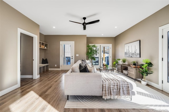 living room with light hardwood / wood-style flooring and ceiling fan