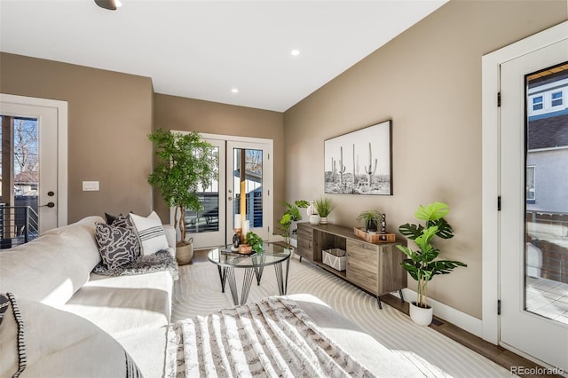 living room featuring light hardwood / wood-style floors, a wealth of natural light, and french doors