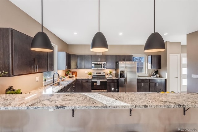 kitchen featuring pendant lighting, stainless steel appliances, sink, kitchen peninsula, and dark brown cabinets