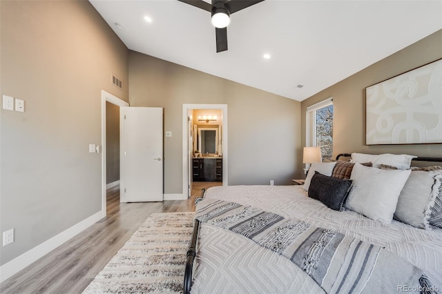 bedroom with high vaulted ceiling, light wood-type flooring, ensuite bath, and ceiling fan