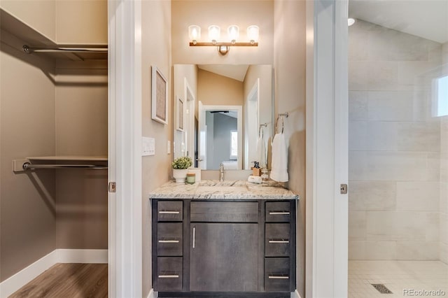 bathroom with vanity, wood-type flooring, and lofted ceiling