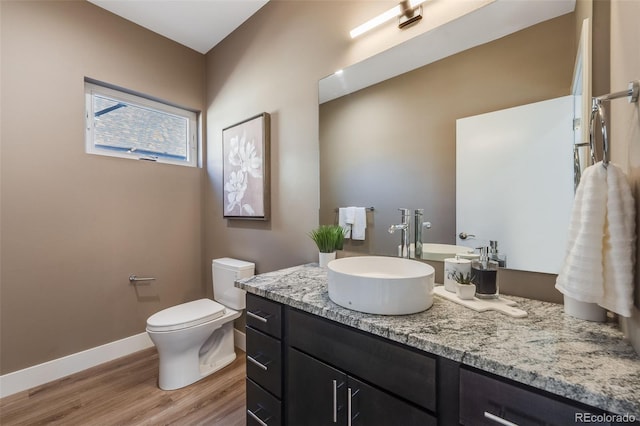 bathroom featuring vanity, toilet, and hardwood / wood-style flooring