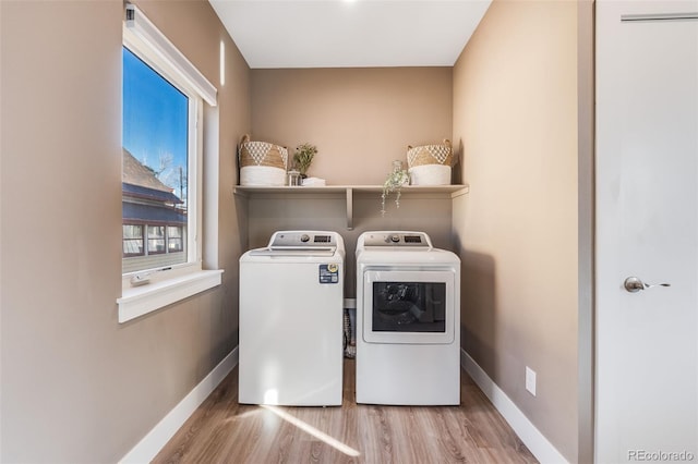 laundry room featuring washer and dryer and light wood-type flooring