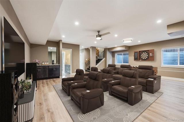 cinema room with light hardwood / wood-style flooring and ceiling fan