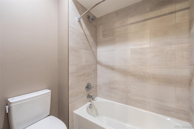 bathroom featuring tiled shower / bath combo and toilet