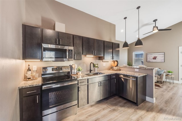 kitchen with appliances with stainless steel finishes, sink, decorative light fixtures, dark brown cabinets, and kitchen peninsula