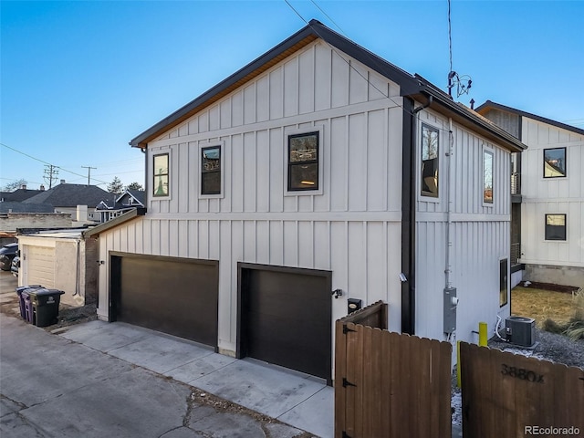 view of property exterior with a garage and central AC