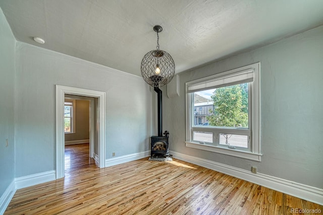 144 N C St, Salida, CO 81201 - unfurnished dining area featuring a wood stove, light wood finished floors, and baseboards