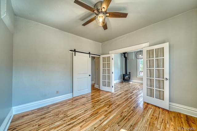 144 N C St, Salida, CO 81201 - unfurnished room featuring wood finished floors, baseboards, ceiling fan, and a wood stove
