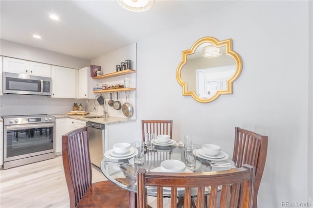 dining area with light wood-type flooring and sink