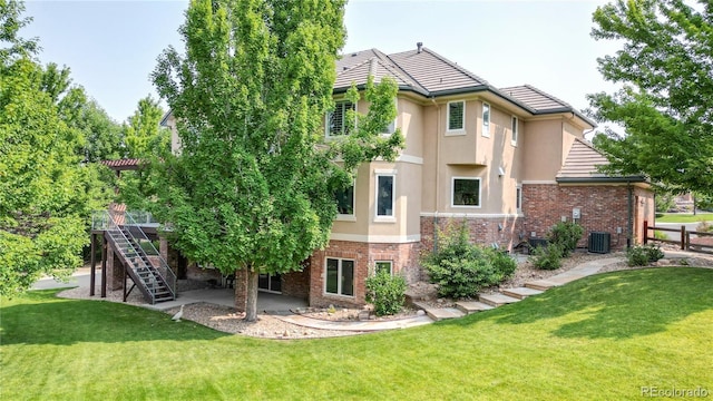 back of property with a yard and central AC unit