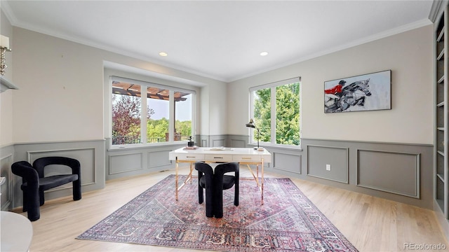 dining area with crown molding, light wood-type flooring, and a wealth of natural light