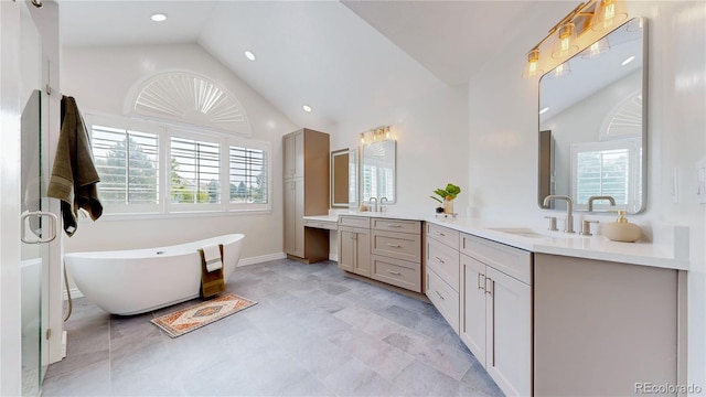 bathroom with lofted ceiling, vanity, and a bathtub