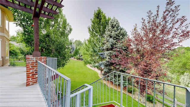 wooden terrace featuring a lawn