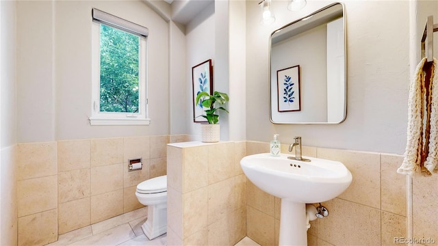 bathroom with tile walls, sink, tile patterned floors, and toilet