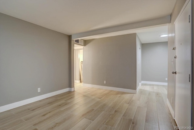 spare room featuring baseboards, visible vents, and light wood finished floors