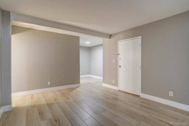 unfurnished room with baseboards and wood finished floors