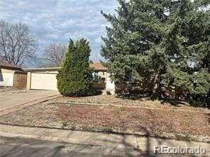 view of property hidden behind natural elements featuring a garage