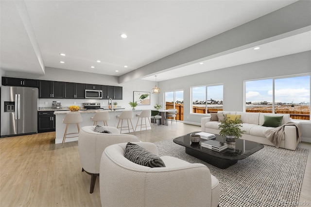 living area with light wood-style floors and recessed lighting