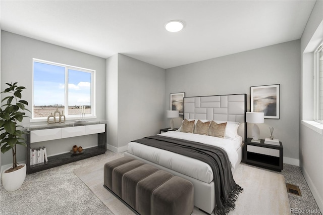 bedroom featuring light colored carpet, visible vents, and baseboards