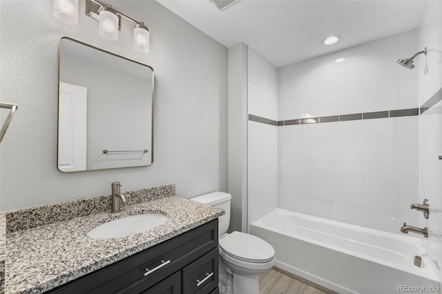 full bathroom featuring vanity, wood finished floors, bathtub / shower combination, and toilet