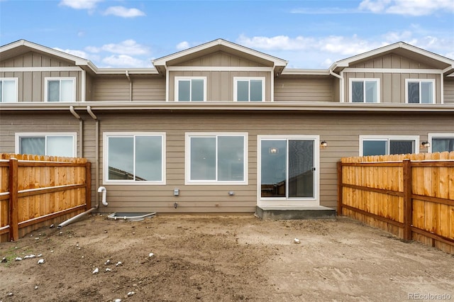 back of house with a fenced backyard and board and batten siding