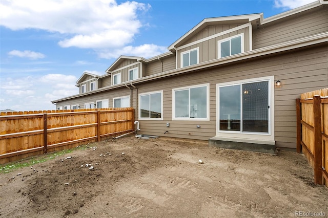 rear view of property featuring board and batten siding and a fenced backyard