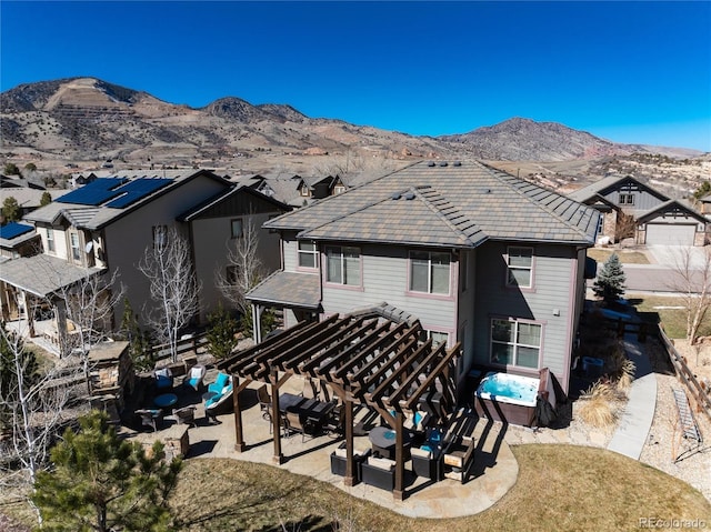 back of house with a mountain view and a patio