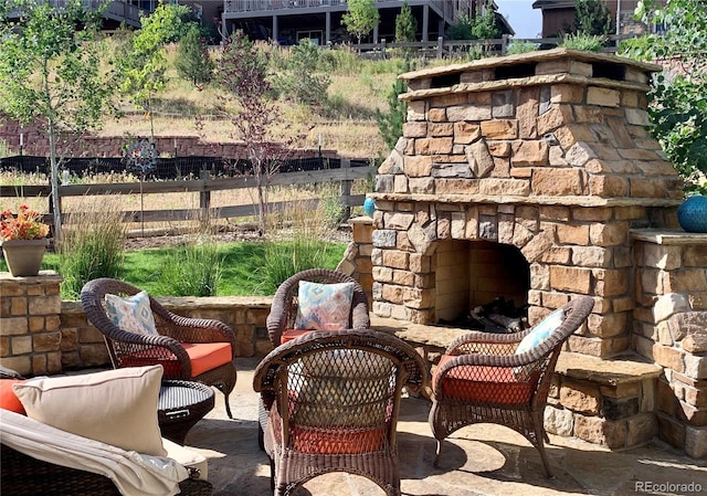 view of patio featuring an outdoor stone fireplace and fence