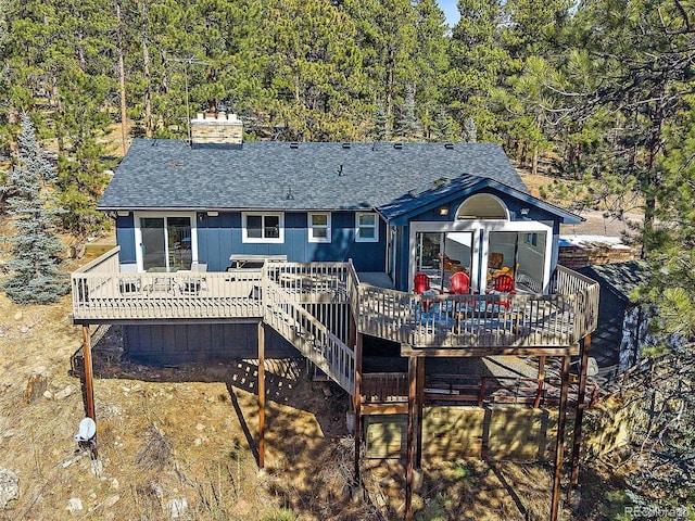 back of property with a chimney, stairway, a wooden deck, and a shingled roof