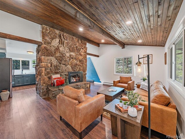 living room with dark wood-type flooring, wooden ceiling, a fireplace, baseboard heating, and vaulted ceiling with beams