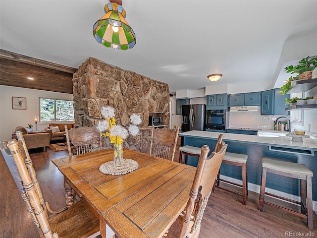 dining area featuring beam ceiling and wood finished floors