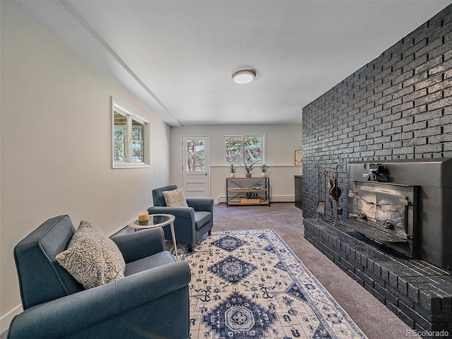 carpeted living room with a brick fireplace, baseboards, and a textured ceiling