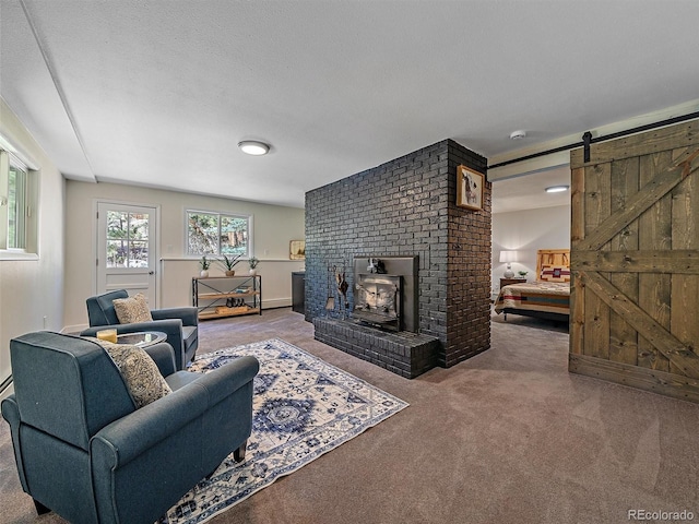 living area with a textured ceiling, a barn door, and carpet floors