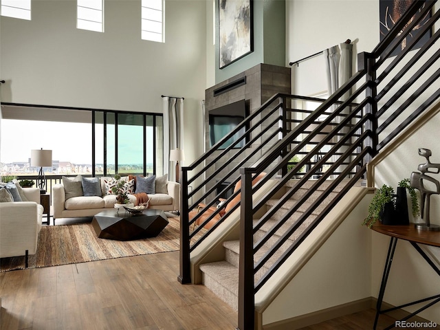 staircase featuring hardwood / wood-style floors and a high ceiling