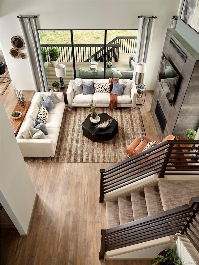 living room with a tiled fireplace and wood-type flooring