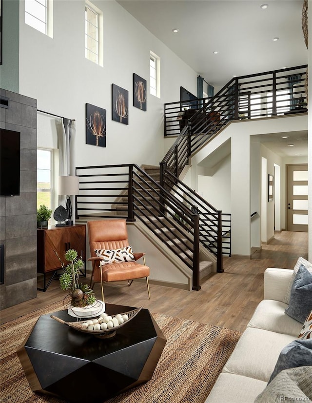 living room with a towering ceiling and hardwood / wood-style floors