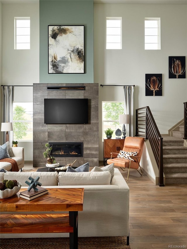 living room featuring a tile fireplace, hardwood / wood-style flooring, and a healthy amount of sunlight