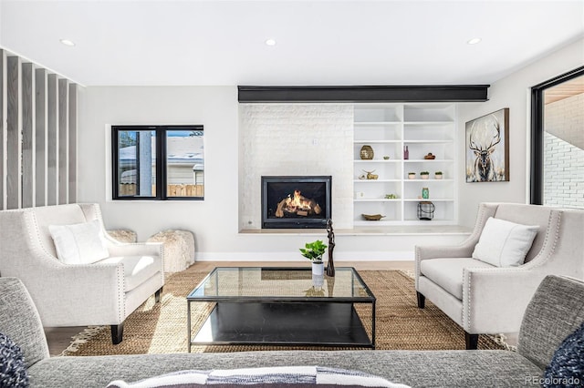 living room featuring a fireplace, built in features, and recessed lighting