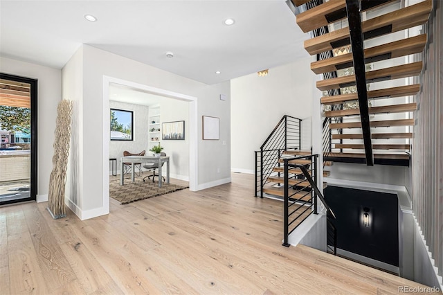 interior space with baseboards, light wood finished floors, stairway, and recessed lighting