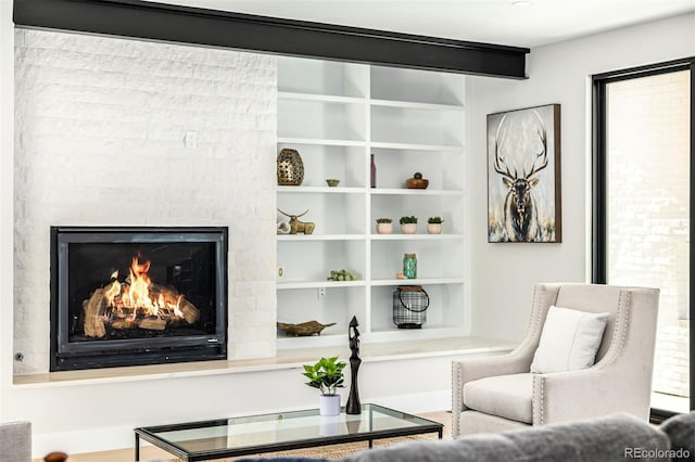 sitting room featuring a glass covered fireplace