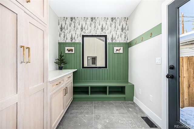 mudroom with wallpapered walls, baseboards, and visible vents