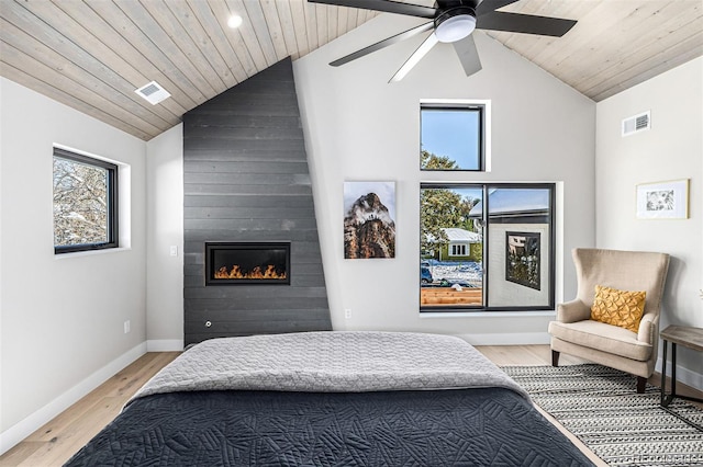 bedroom with lofted ceiling, light wood-style flooring, visible vents, and baseboards