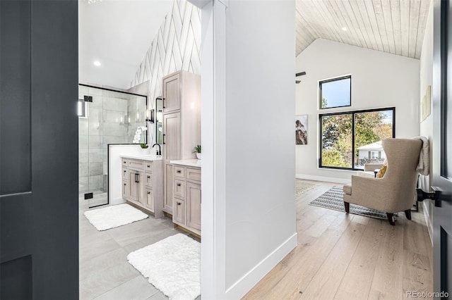 full bath featuring high vaulted ceiling, wood finished floors, vanity, baseboards, and a shower stall