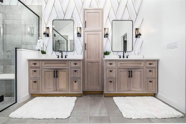 full bath with a shower stall, two vanities, and a sink