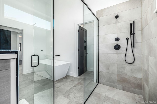 full bathroom featuring a stall shower and a soaking tub