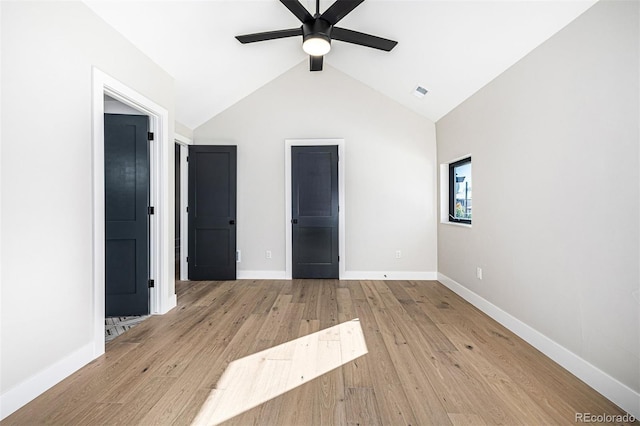 unfurnished bedroom with vaulted ceiling, wood finished floors, visible vents, and baseboards