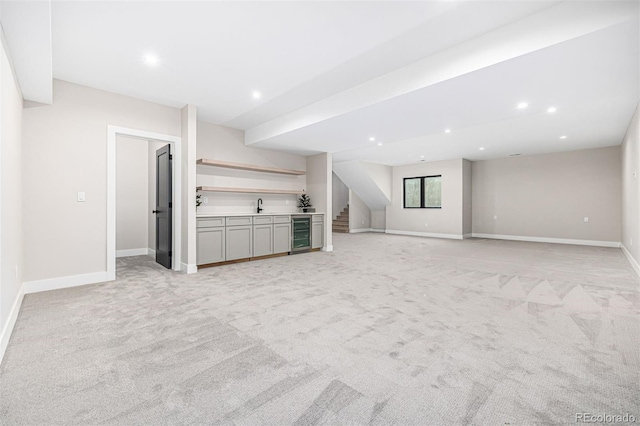 unfurnished living room with wet bar, beverage cooler, a sink, and recessed lighting