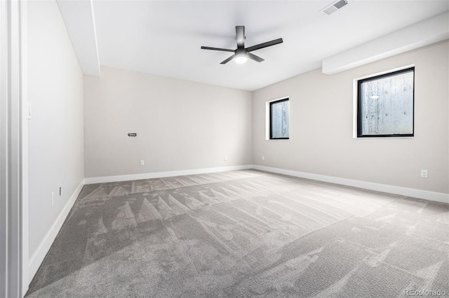 carpeted empty room with a ceiling fan, visible vents, and baseboards